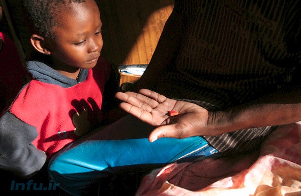 ایتبلنگ گاوسودیوه، مبتلا به ایدز، داروهای پیش‌گیرانه‌اش را به فرزند خود نشان می‌دهد. آن‌ها ساکن حومه گابورون، پایتخت بوتسوانا هستند؛ و هرچند که والدین هر دو به ایدز مبتلا شده‌اند، اما هیچ‌کدام از پنج فرزندشان به این بیماری مبتلا نیست / رویترز.